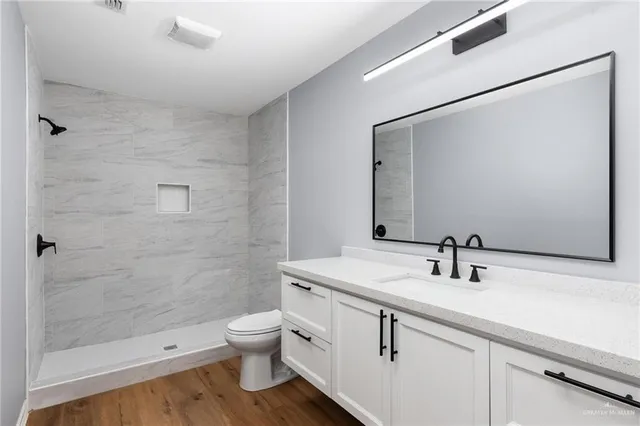 a bathroom with a sink a toilet and shower