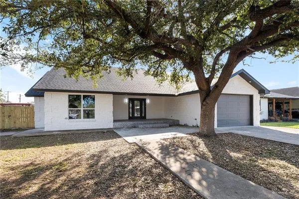 a front view of a house with yard and trees
