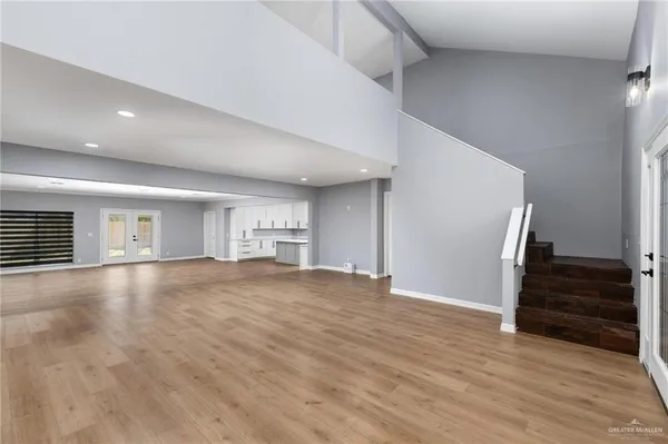 a view of empty room with wooden floor and entryway