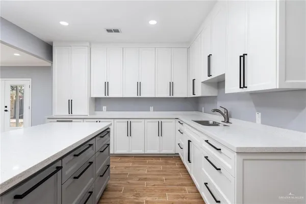 a kitchen with granite countertop white cabinets and white appliances