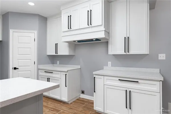 a kitchen with white cabinets and sink