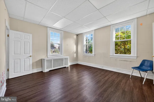 a view of a livingroom with wooden floor and stairs