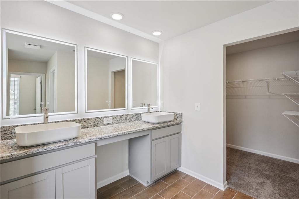 685 Egrets Landing, Unit 58 Covington, GA 30014 - Photo 20 of 41 a bathroom with a granite countertop sink and a mirror