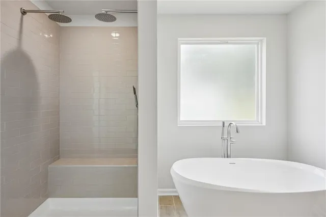 a bathroom with a shower and a bath tub