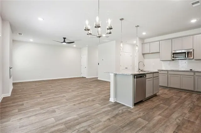 a kitchen with granite countertop a stove a sink and a refrigerator