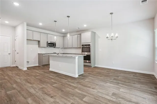 a view of kitchen with granite countertop cabinets and refrigerator