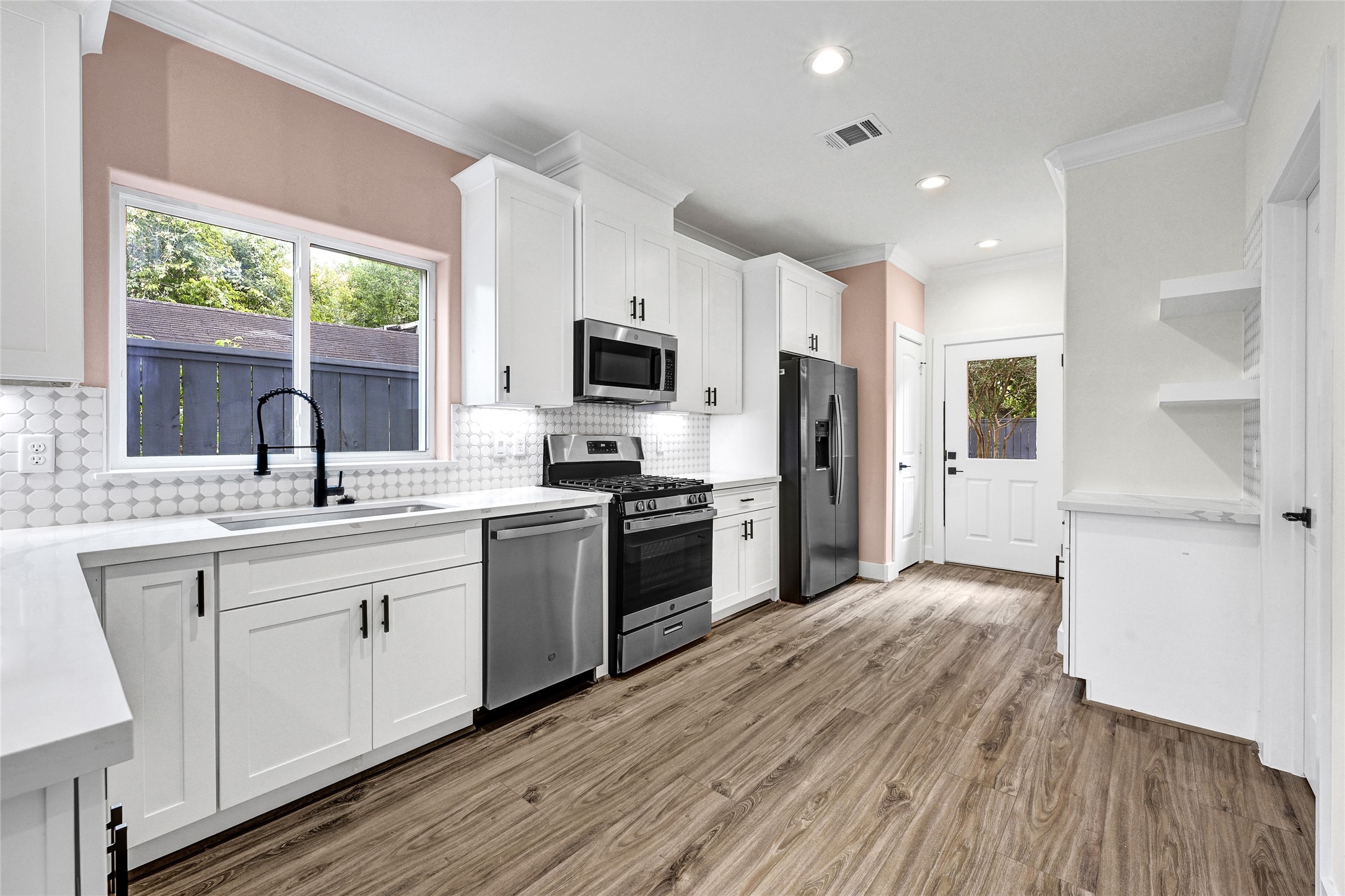 3834 Mt Pleasant Street Houston, TX 77021 - Photo 13 of 50 a kitchen with a sink wooden floor and stainless steel appliances