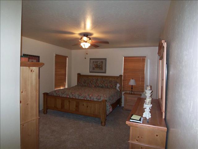 7168 Moon Pinetop, AZ 85935 - Photo 4 of 5 a spacious bedroom with a bed and a chandelier
