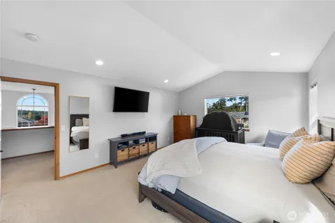 a spacious bedroom with a bed and a television