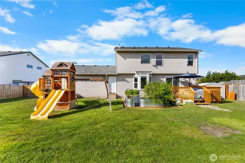 a view of a house with a big yard and a fountain