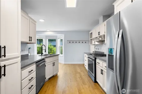 a kitchen with stainless steel appliances a sink stove and refrigerator