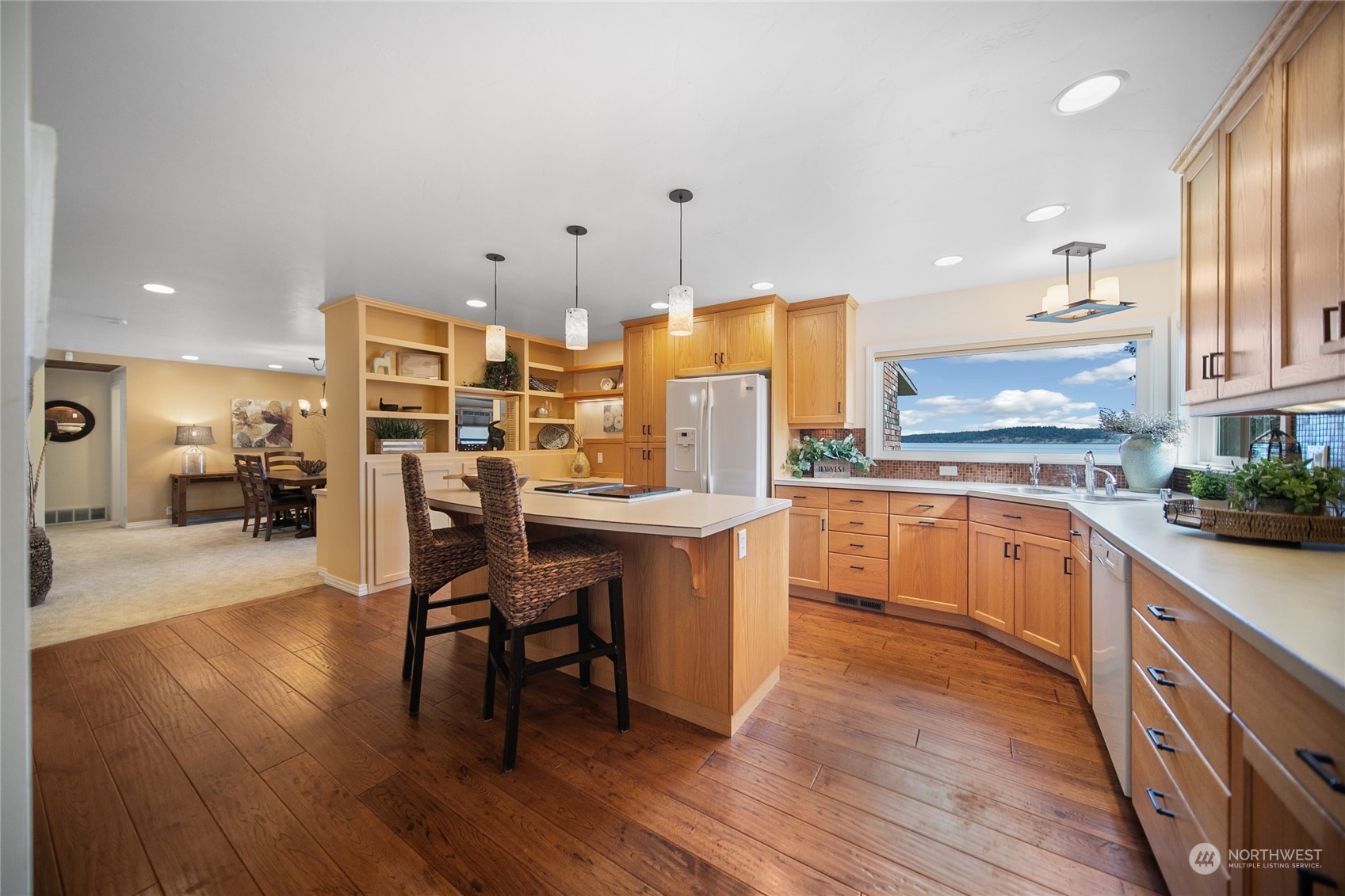 3217 West Sequim Bay Road Sequim, WA 98382 - Photo 6 of 40 a kitchen with stainless steel appliances kitchen island granite countertop wooden floors and white cabinets
