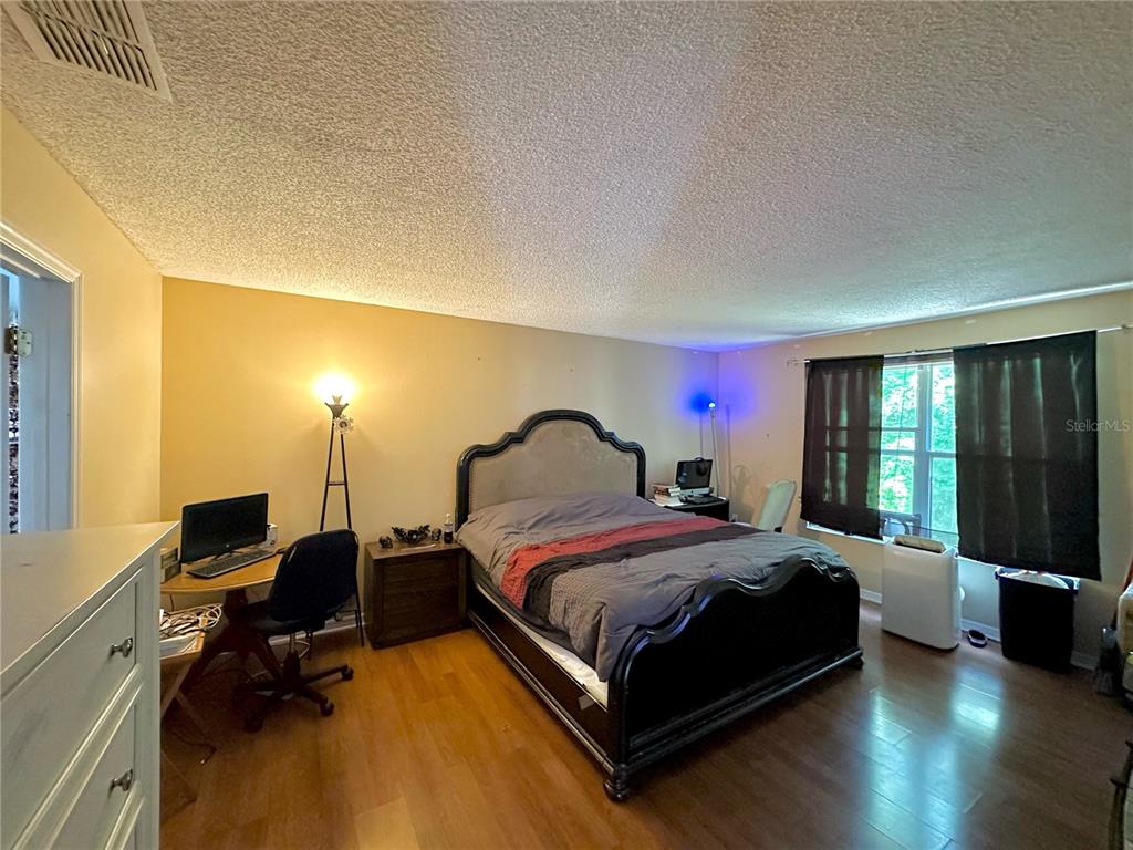 1225 Stone Harbour Road Winter Springs, FL 32708 - Photo 14 of 23 a bedroom with a bed and wooden floor