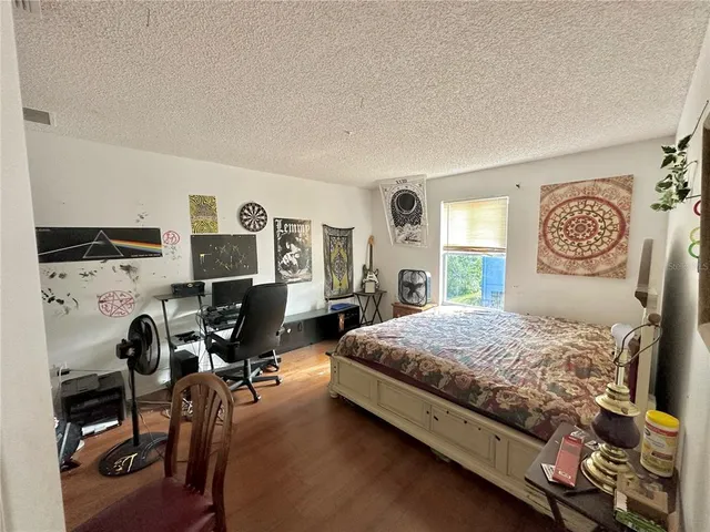 a bedroom with a bed a chair and a large window