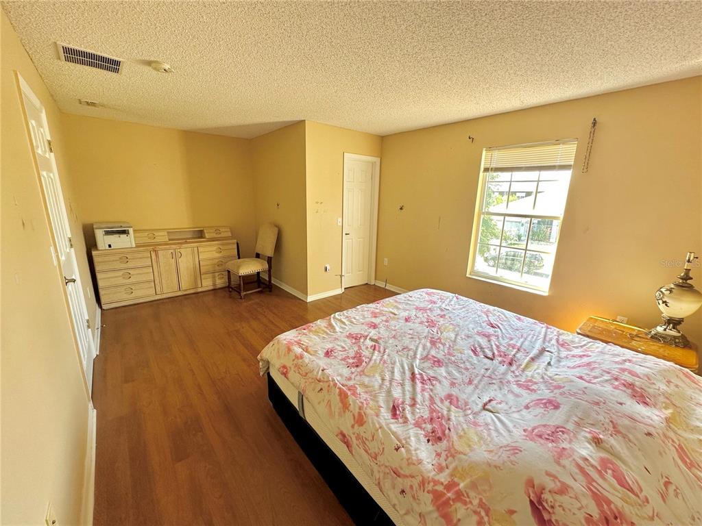 1225 Stone Harbour Road Winter Springs, FL 32708 - Photo 19 of 23 a bedroom with a bed and wooden floor