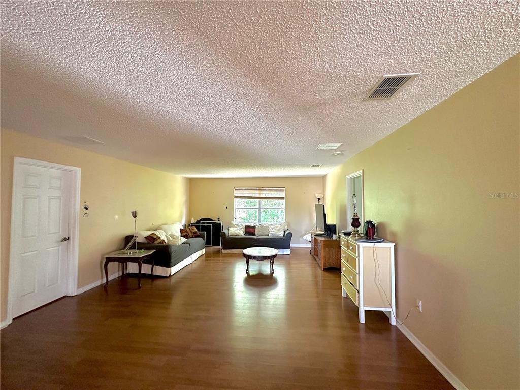 1225 Stone Harbour Road Winter Springs, FL 32708 - Photo 2 of 23 a living room with couches and kitchen view with wooden floor