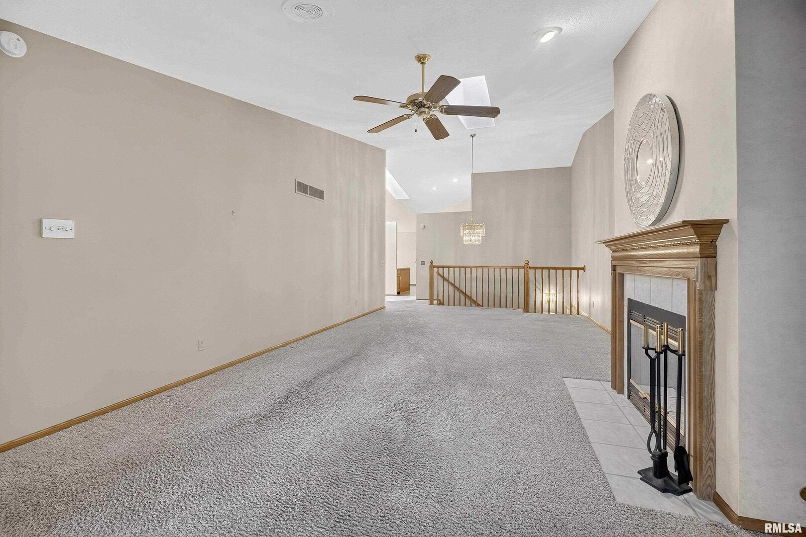 3988 Partridge Circle Bettendorf, IA 52722 - Photo 11 of 42 en empty room with fireplace and fan