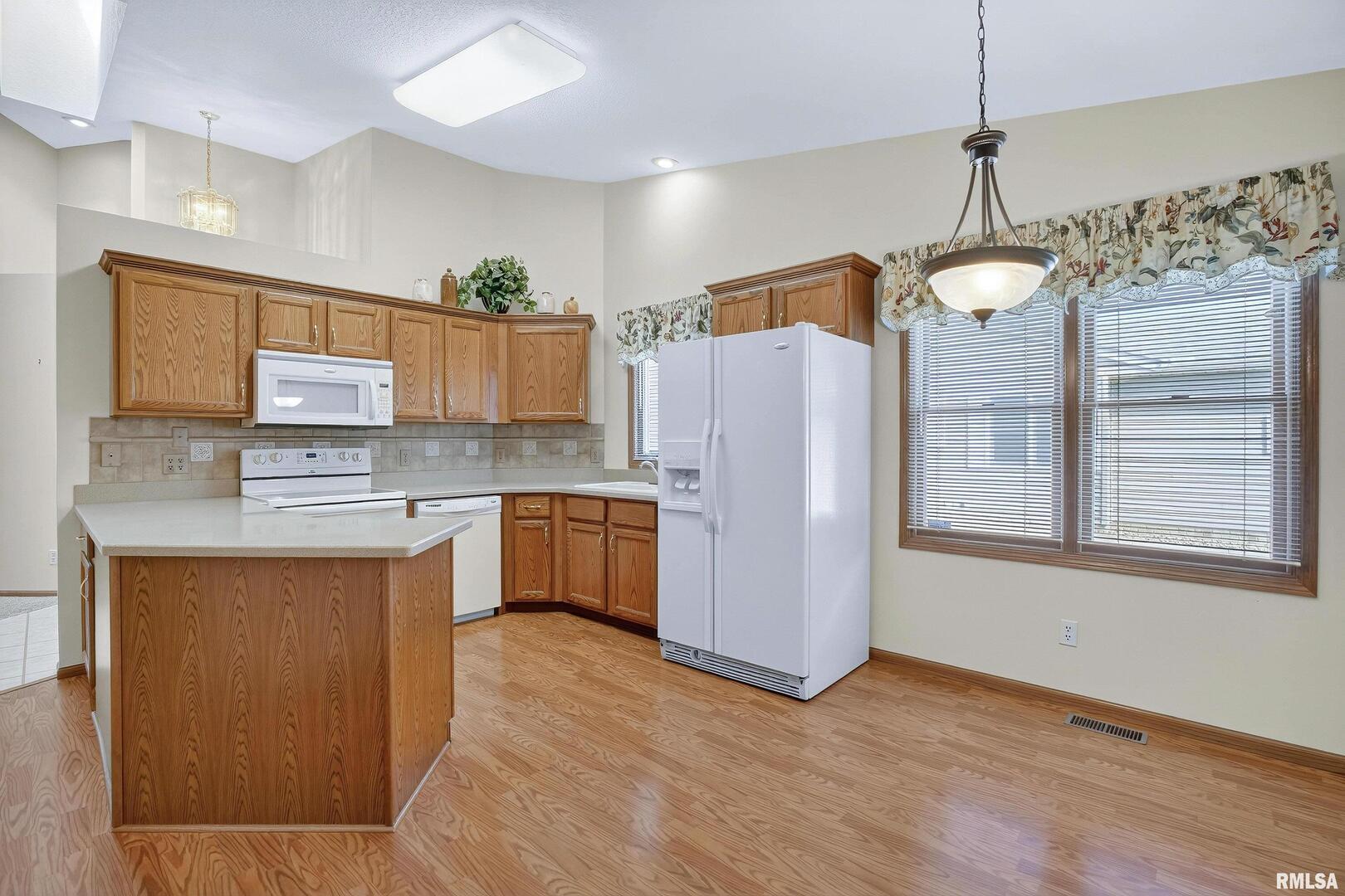 3988 Partridge Circle Bettendorf, IA 52722 - Photo 26 of 42 a kitchen that has a lot of cabinets a sink and a refrigerator in it