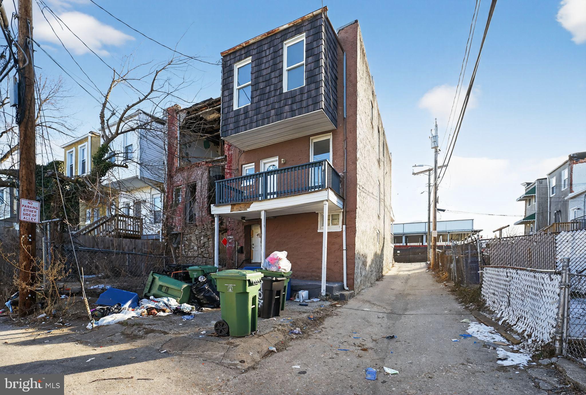 900 North Franklintown Road Baltimore, MD 21216 - Photo 3 of 16 a man walking down a street next to a building