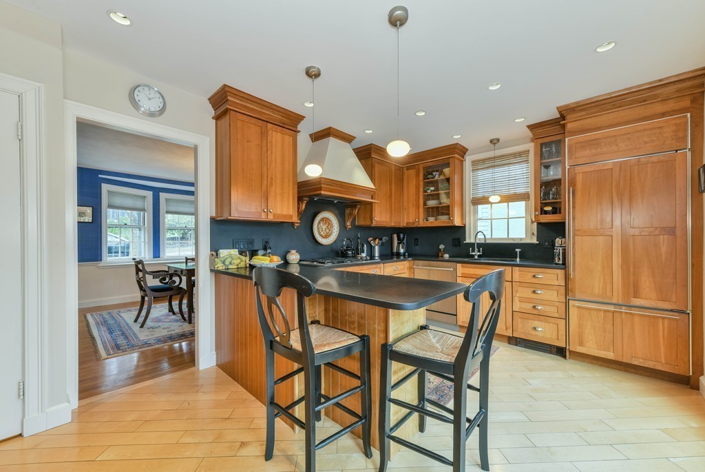 47 Standish Road Milton, MA 02186 - Photo 11 of 23 a kitchen with stainless steel appliances granite countertop a stove a sink a refrigerator a dining table and chairs with wooden floor