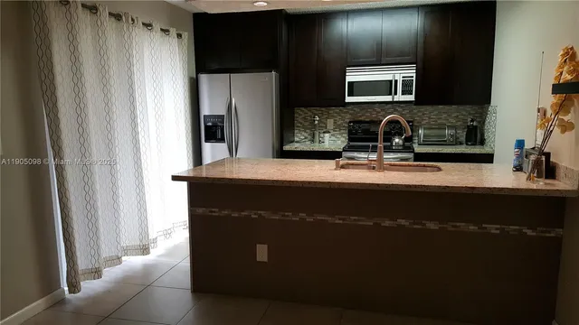 a kitchen with a refrigerator and a sink