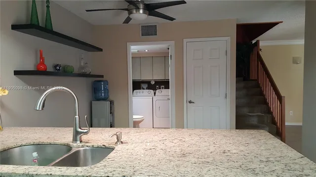 a kitchen with a sink a refrigerator and cabinets