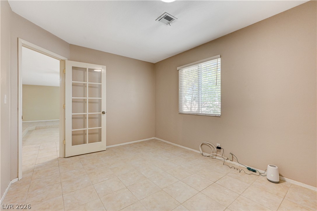7631 Bermuda Road Las Vegas, NV 89123 - Photo 28 of 64 An inviting room features tiled flooring and a glass-paneled door, perfect for a home office.