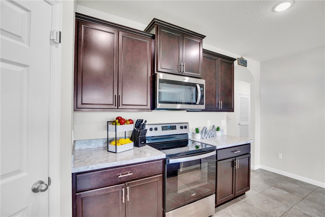 3453 Trinity Circle Fort Pierce, FL 34945 - Photo 6 of 36 a kitchen with stainless steel appliances a sink stove and refrigerator