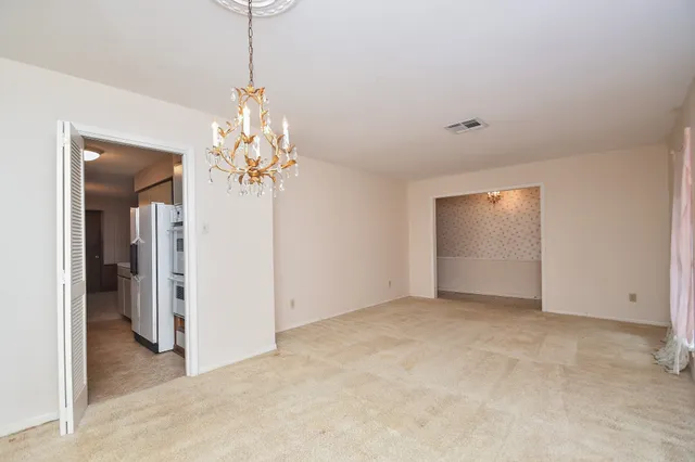 an empty room with windows and chandelier