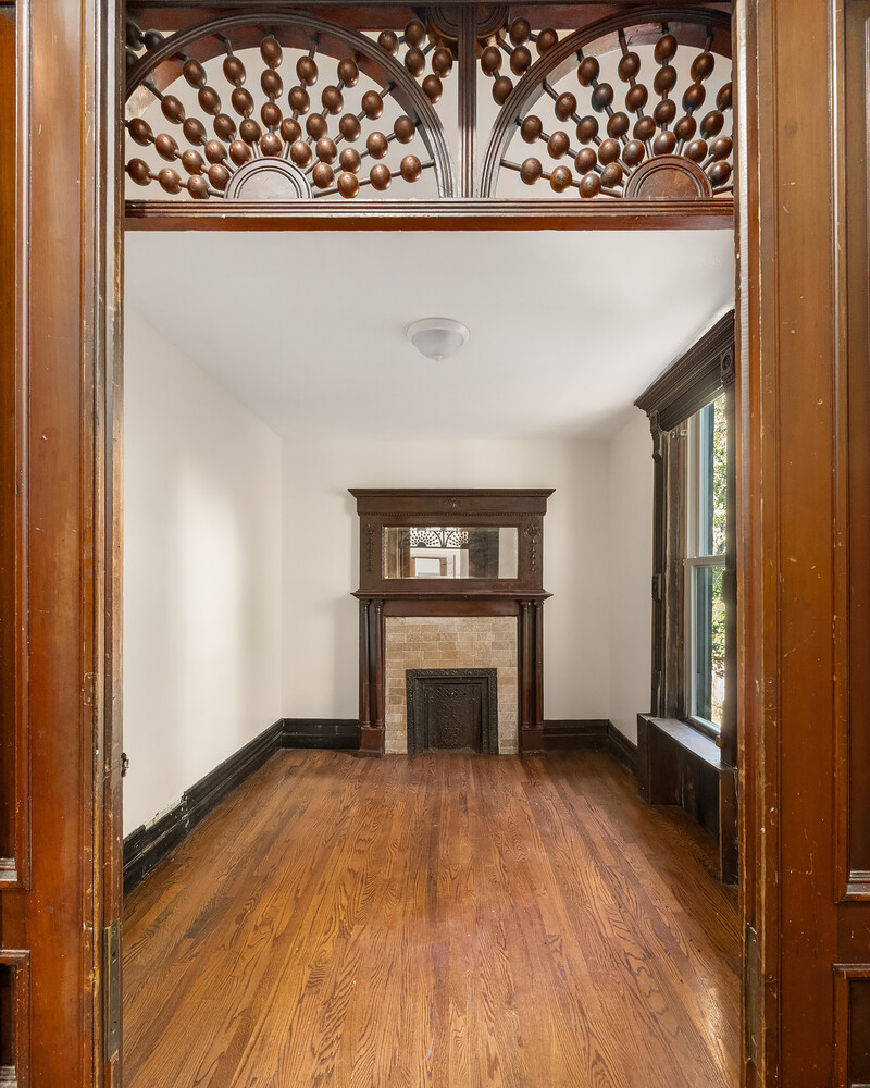 497 Decatur Street Brooklyn, NY 11233 - Photo 14 of 21 a view of an empty room with wooden floor and a window