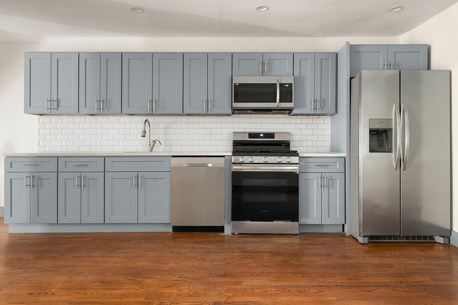 497 Decatur Street Brooklyn, NY 11233 - Photo 5 of 21 a kitchen with stainless steel appliances a stove a sink and a microwave