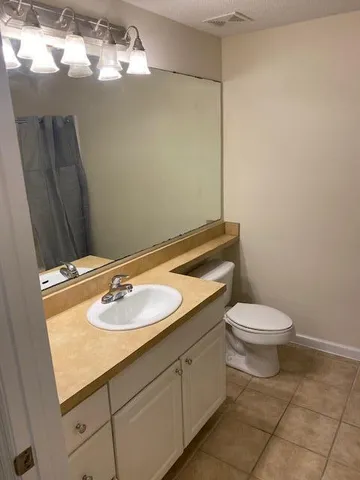 a bathroom with a sink a toilet and mirror