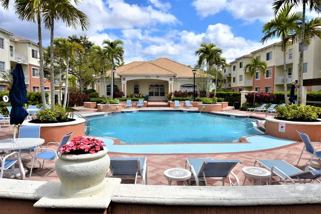 a view of a white house with a swimming pool and a dining table