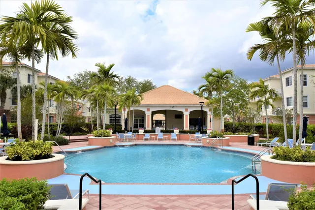 a view of an house with swimming pool and chairs