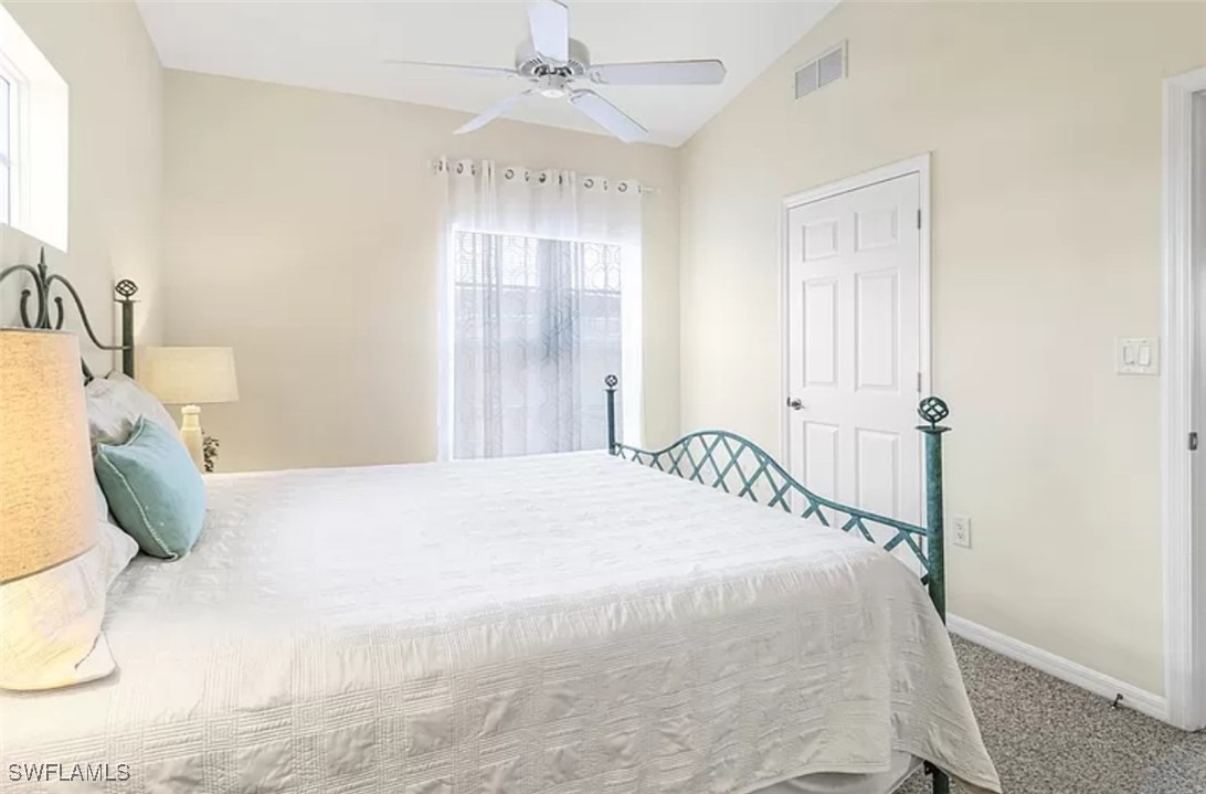4450 Botanical Pl Circle, Unit 6 Naples, FL 34112 - Photo 14 of 33 a bedroom with a bed and a chandelier
