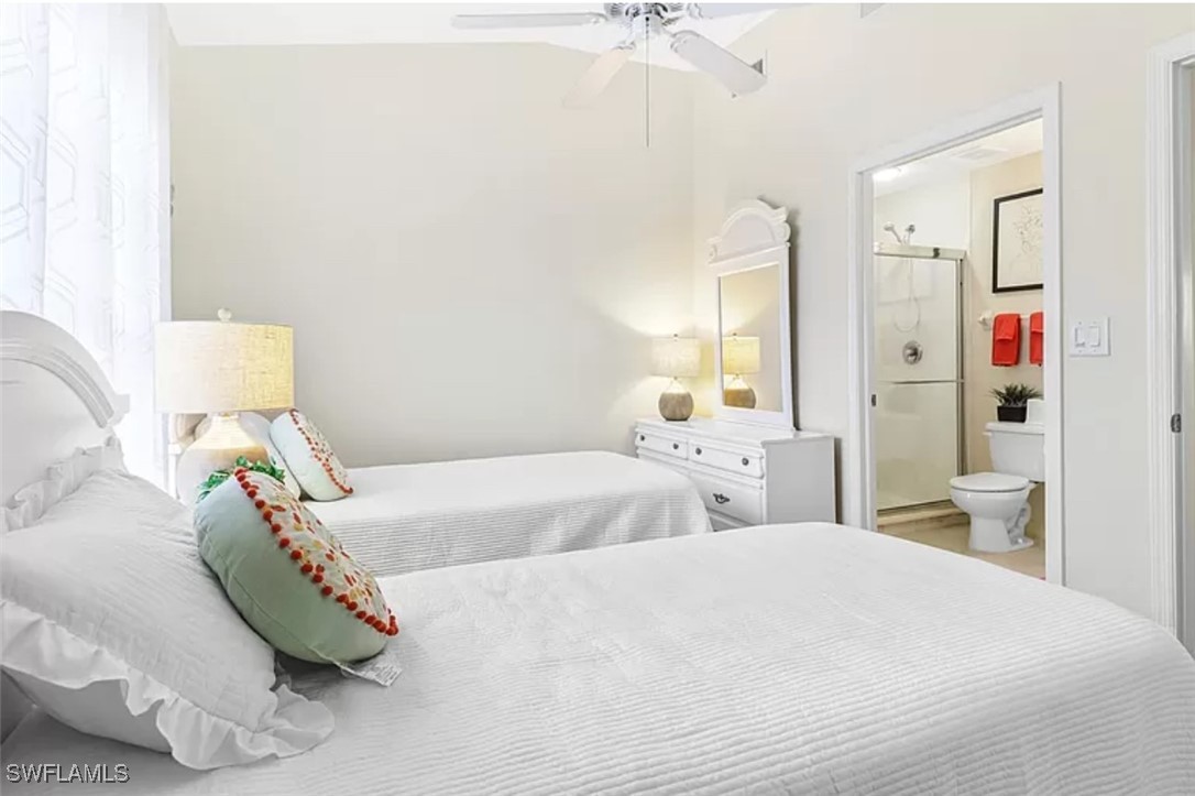 4450 Botanical Pl Circle, Unit 6 Naples, FL 34112 - Photo 15 of 33 a bedroom with a bed and a chandelier