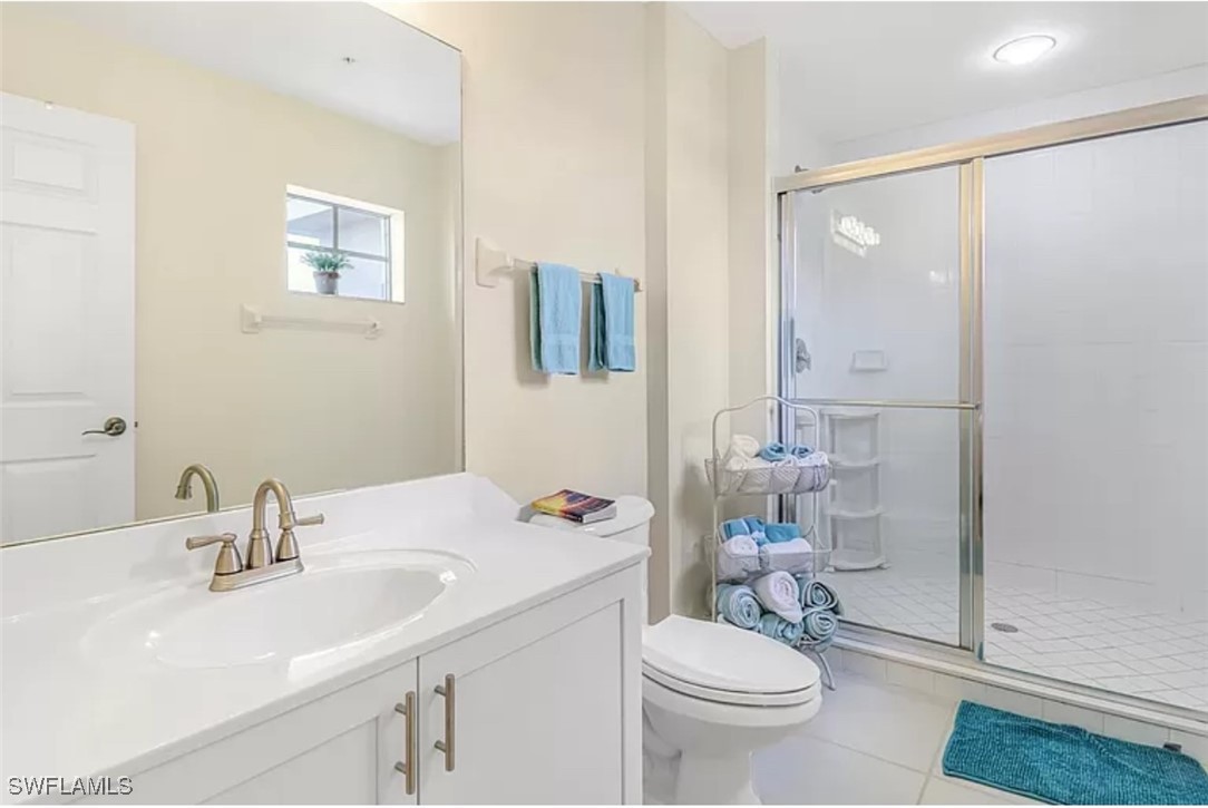 4450 Botanical Pl Circle, Unit 6 Naples, FL 34112 - Photo 20 of 33 a bathroom with a sink toilet a mirror and shower