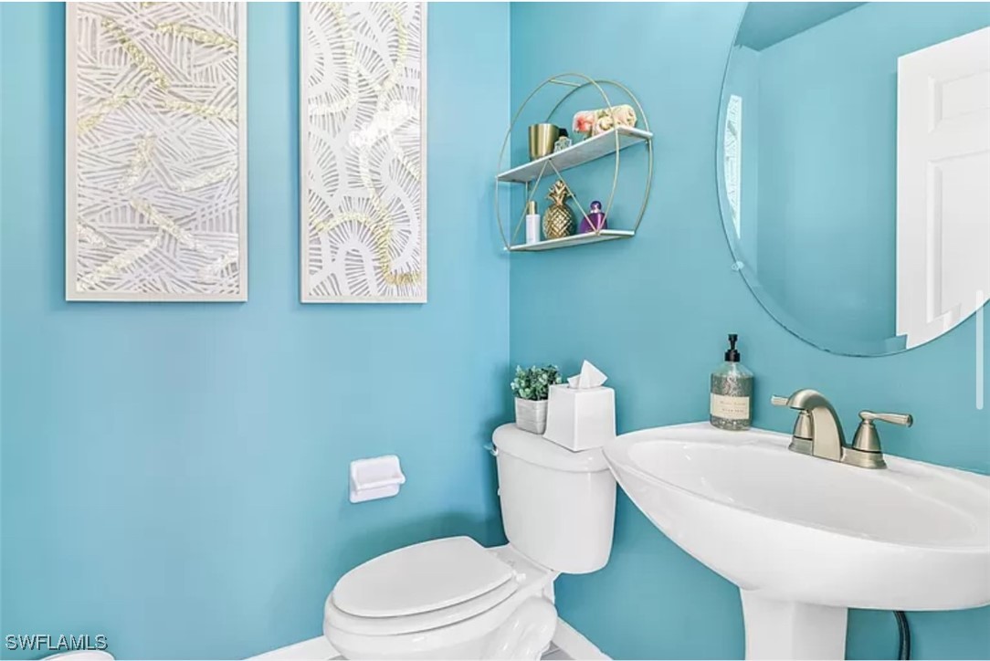 4450 Botanical Pl Circle, Unit 6 Naples, FL 34112 - Photo 22 of 33 a white toilet sitting next to a bathroom sink