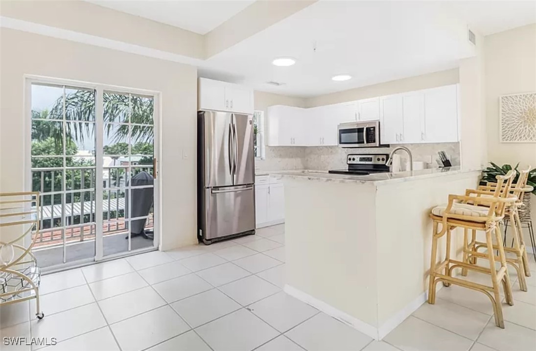 4450 Botanical Pl Circle, Unit 6 Naples, FL 34112 - Photo 25 of 33 a kitchen with stainless steel appliances a refrigerator sink and microwave