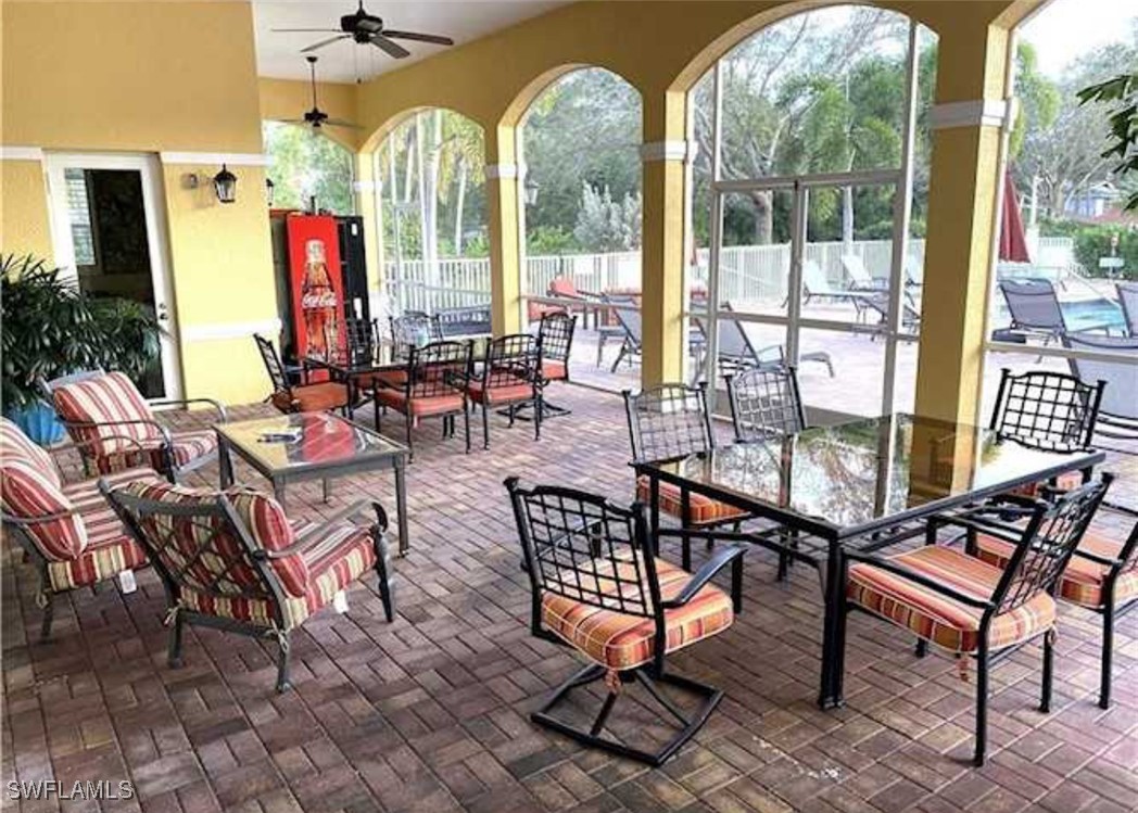 4450 Botanical Pl Circle, Unit 6 Naples, FL 34112 - Photo 31 of 33 a outdoor space with lots of furniture and glass windows