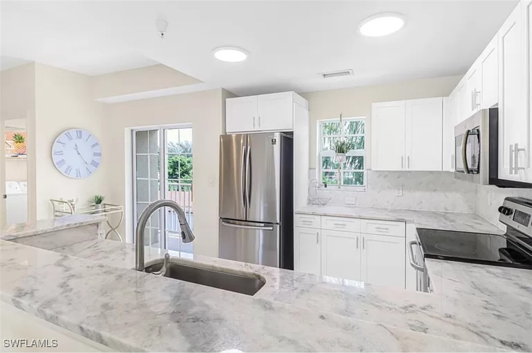 4450 Botanical Pl Circle, Unit 6 Naples, FL 34112 - Photo 4 of 33 a kitchen with stainless steel appliances granite countertop a refrigerator a stove a sink and a refrigerator