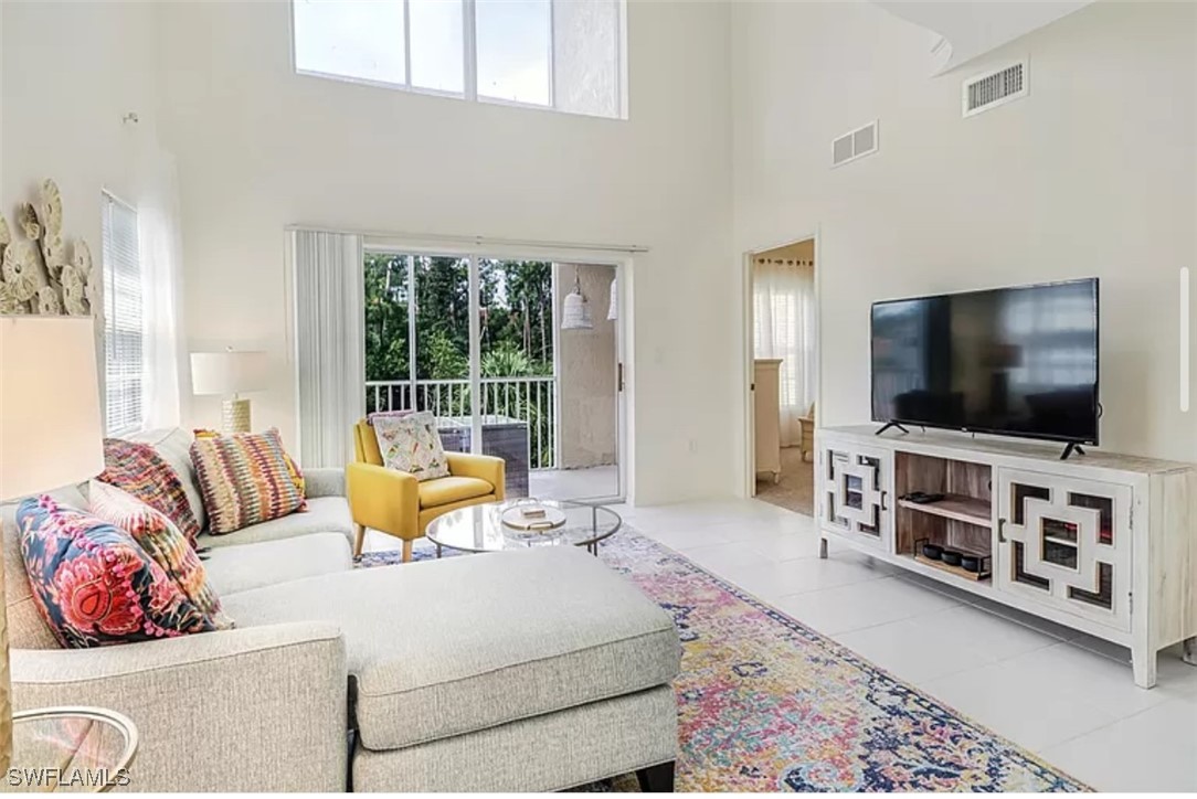 4450 Botanical Pl Circle, Unit 6 Naples, FL 34112 - Photo 5 of 33 a living room with furniture and a flat screen tv