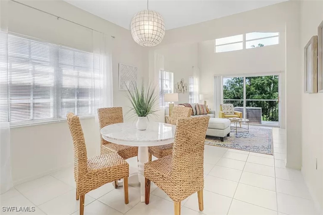 4450 Botanical Pl Circle, Unit 6 Naples, FL 34112 - Photo 6 of 33 a view of a dining room with furniture wooden floor and chandelier