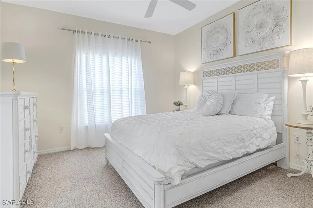 4450 Botanical Pl Circle, Unit 6 Naples, FL 34112 - Photo 9 of 33 a large bed sitting in a room next to a window