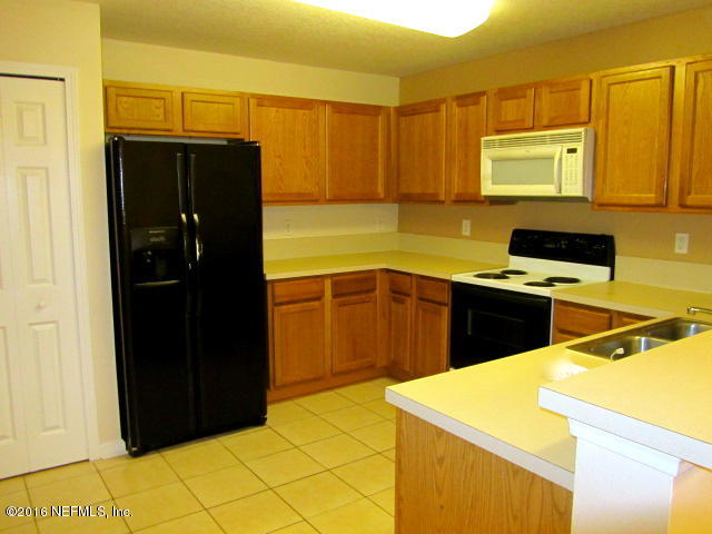 a kitchen with a refrigerator and a stove