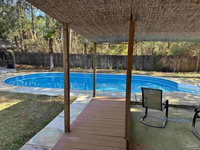 a view of swimming pool with a table and chairs in patio