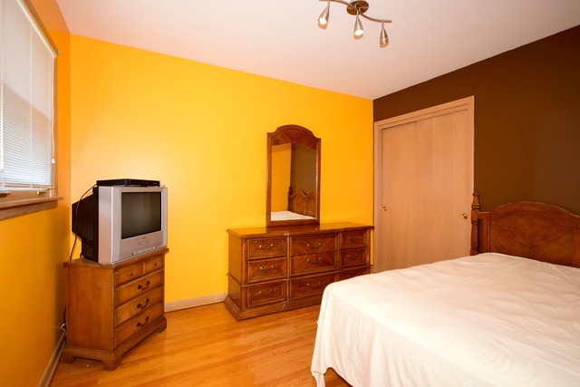 7301 West Roscoe Street Chicago, IL 60634 - Photo 14 of 22 a bedroom with a bed and wooden floor