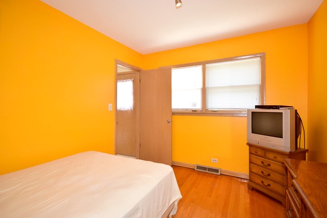 7301 West Roscoe Street Chicago, IL 60634 - Photo 15 of 22 a bedroom with a bed and a flat screen tv