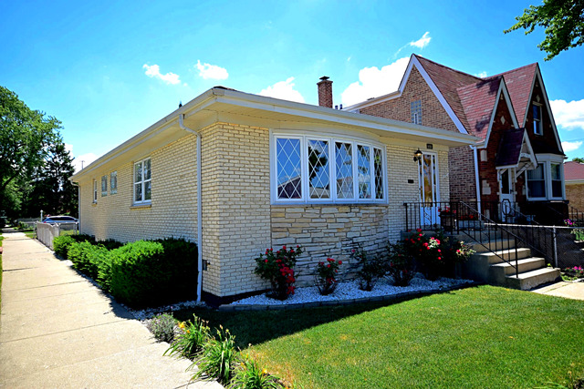 7301 West Roscoe Street Chicago, IL 60634 - Photo 2 of 22 a front view of a house with garden