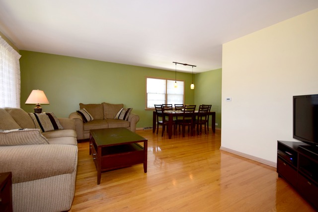 7301 West Roscoe Street Chicago, IL 60634 - Photo 3 of 22 a living room with furniture and a flat screen tv